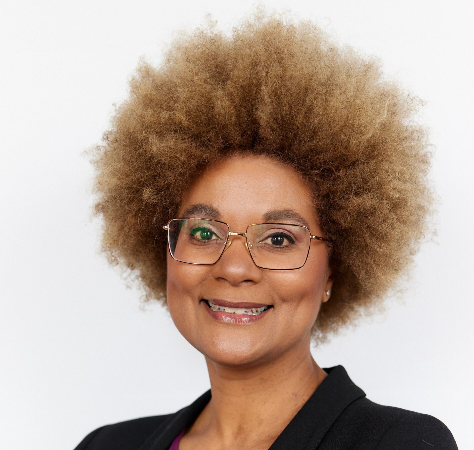Portrait of woman with an afro wearing a black jacket and maroon blouse