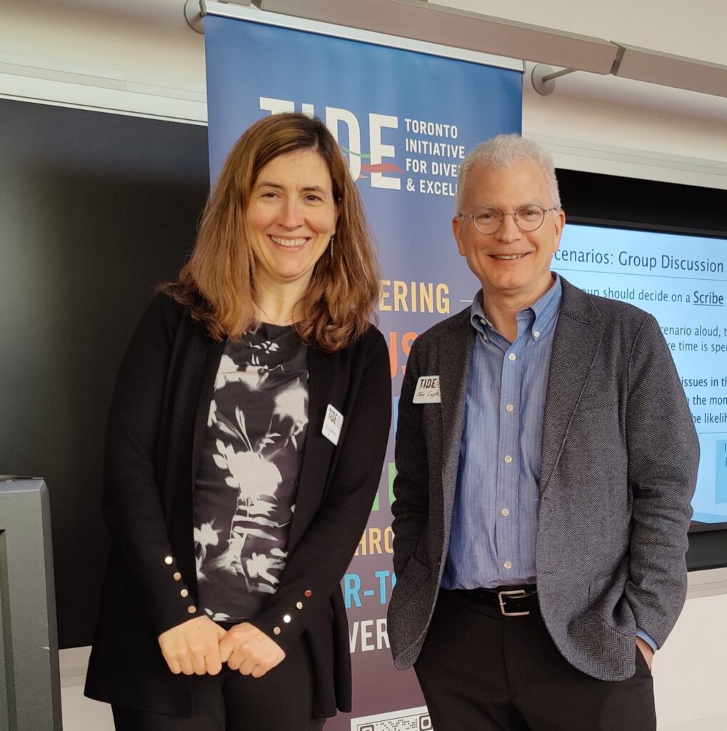 Bojana Stefanovic and Tom Coyle standing in front of a TIDE banner at a workshop held at the Perimeter Institute in Waterloo